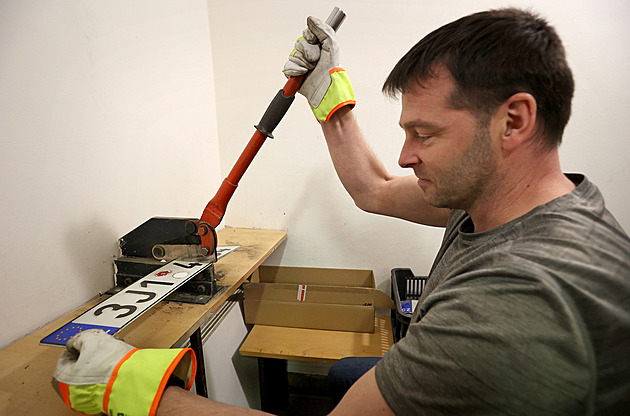 Úředníci skartují stovky registračních značek, stříhají je ručně pákovými nůžkami